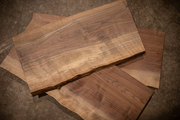 Three small live edge walnut boards standing on end